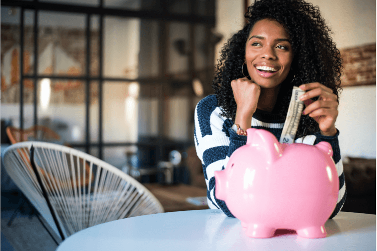 woman putting money into piggy bank