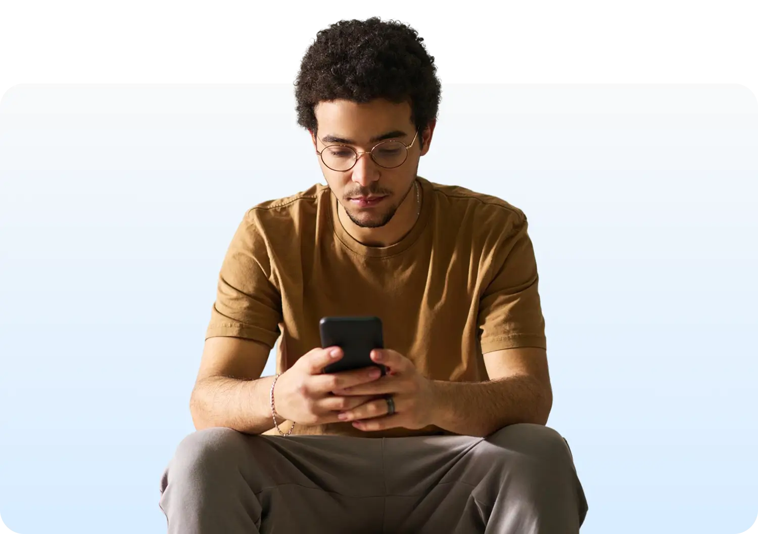 boy checking his phone to compare student lenders