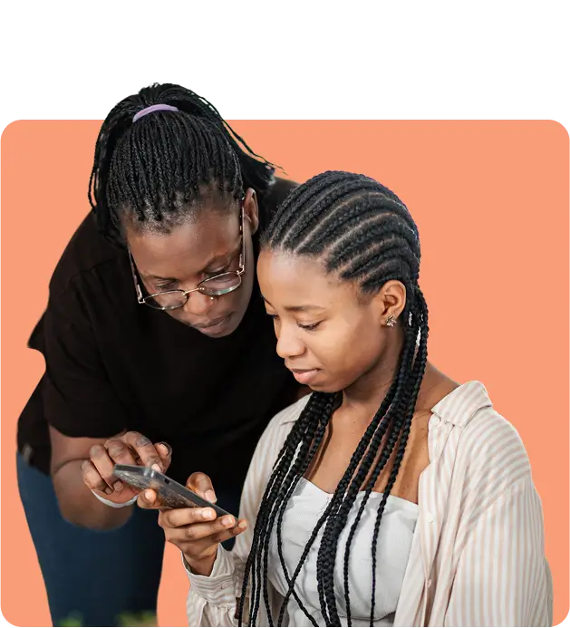 Mother and daughter looking down and interacting with a smartphone together