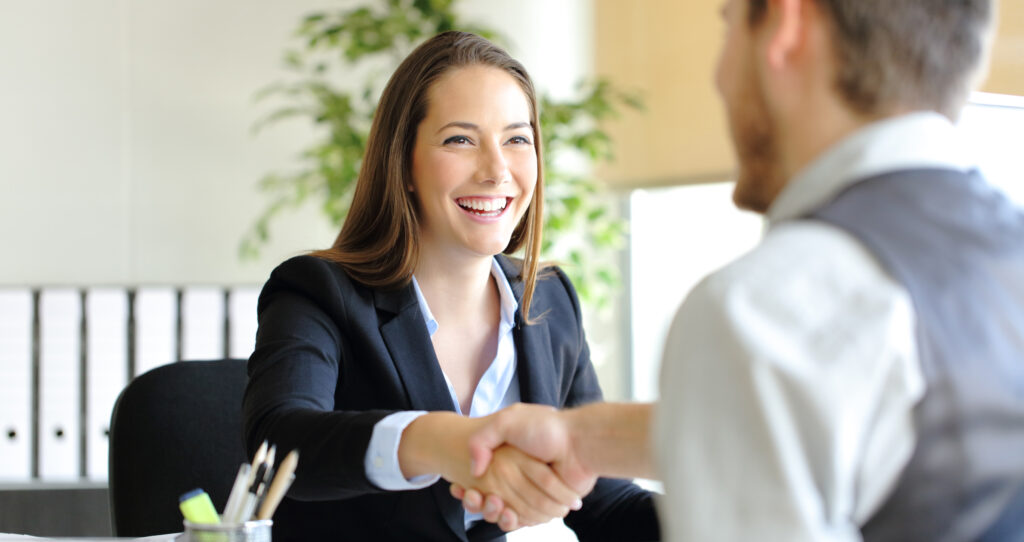 Young woman shakes man's hand