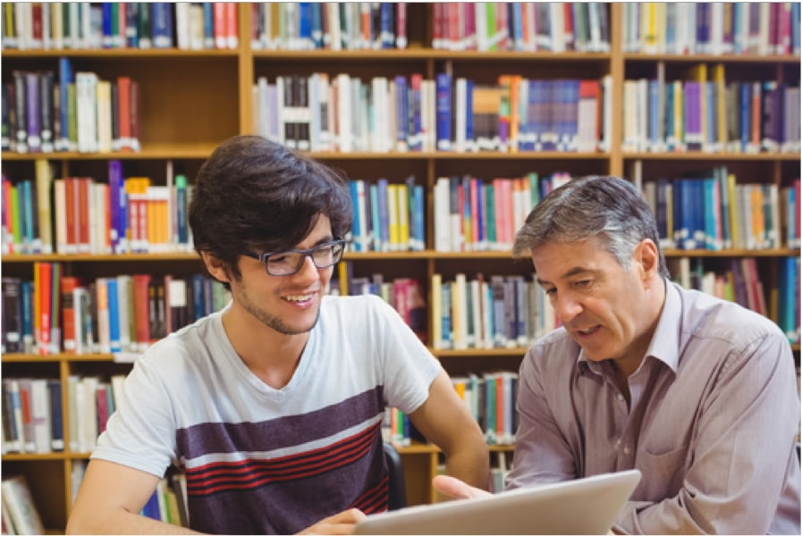 Teacher helping student in library