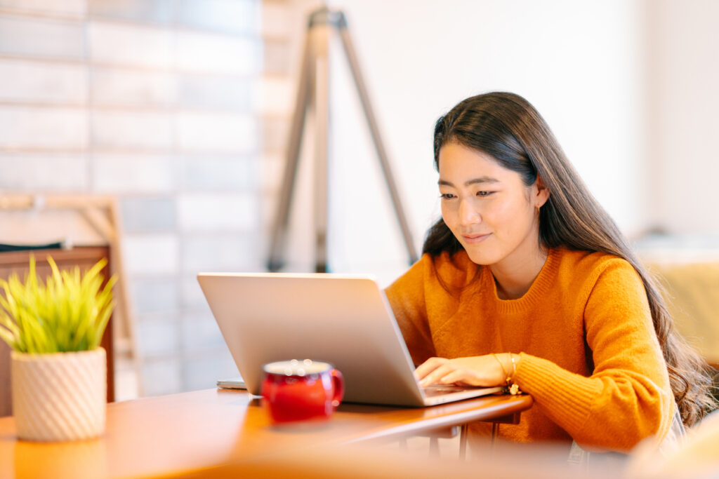 Young female college student sitting in front of computer.