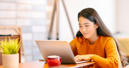 Young female college student sitting in front of computer.