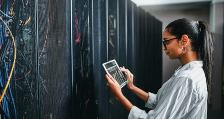 Young woman using a digital tablet while working in cybersecurity