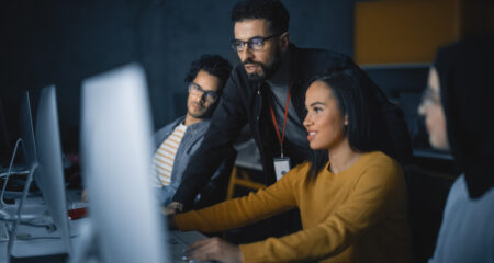 Teacher Giving Lesson to Diverse Group of Students in Software Engineering Bootcamp, Teaching New Skills on a Computer