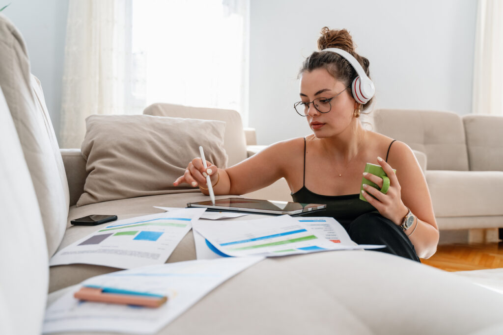 Female college student sitting on floor of her apartment understanding financial decisions