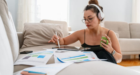 Female college student sitting on floor of her apartment understanding financial decisions