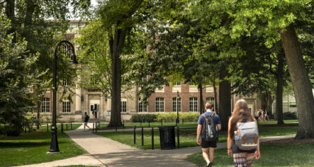 Grad students discussing How Schools Can Rethink Graduate Funding Models After Grad PLUS on a campus