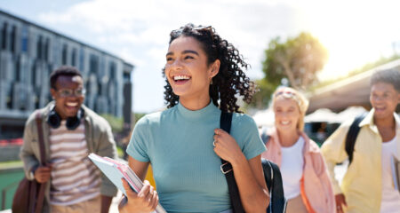 Happy student who learned scholarships can pay for more than just tuition. Learn how scholarship money can be used for books, housing, meals, fees, and other common college expenses.