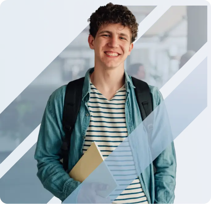 A smiling young male student with curly hair wearing a denim shirt, carrying a backpack and holding a notebook - desktop