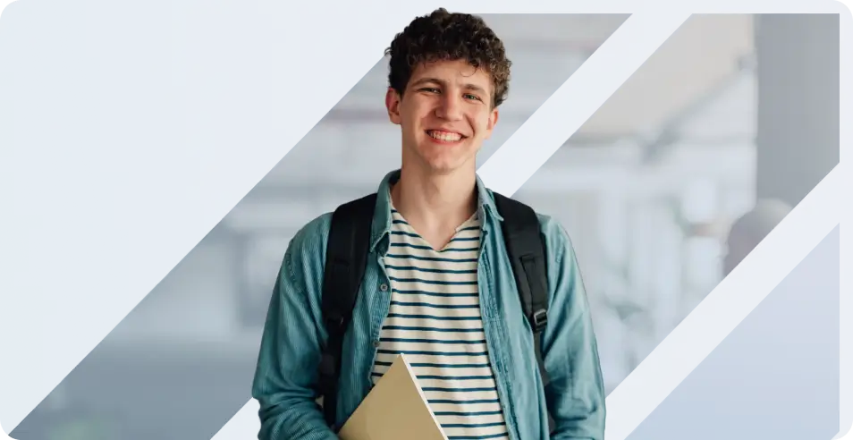 A smiling young male student with curly hair wearing a denim shirt, carrying a backpack and holding a notebook - mobile