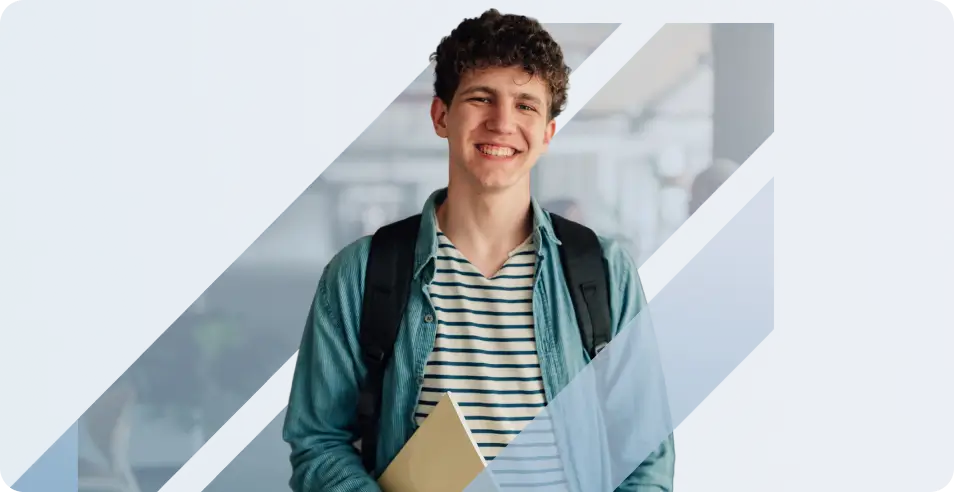 A smiling young male student with curly hair wearing a denim shirt, carrying a backpack and holding a notebook - mobile